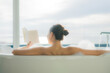 © siraphol - Portrait beautiful young asian woman read book in white bathtub