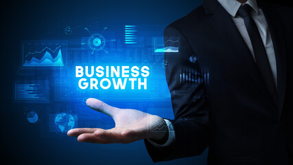 Hand of Businessman holding BUSINESS GROWTH inscription, business success concept