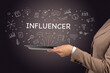 © ra2 studio - Close-up of a touchscreen with INFLUENCER inscription, social media concept