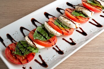 Caprese salad: tomato, fresh mozzarella cheese, fresh basil, balsamic vinegar. 