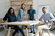 © fizkes - Smiling diverse employees colleagues group portrait in modern boardroom, business people working on financial project statistics together, posing for photo in office, looking at camera