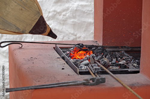 Fotografía bellows of the blacksmith fanning the fire in the coals