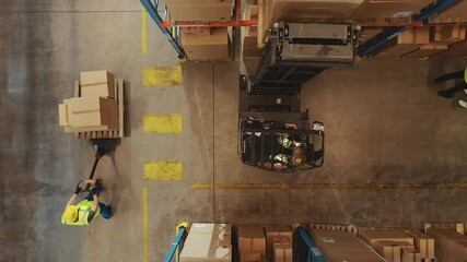 Wall Mural - Top-Down Aerial Drone Shot: Electric Forklift Truck Operator Lifts Pallet with Cardboard Box of in a Big Retail Warehouse a Shelf. Logistics Product and Goods Delivery and Distribution Center