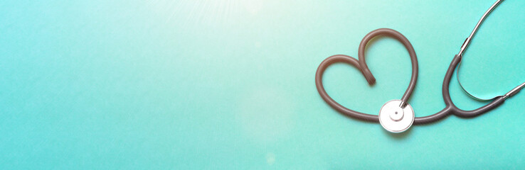 Stethoscope in Shape of Heart Isolated On Green Background. Banner. Copy space. Place for text.