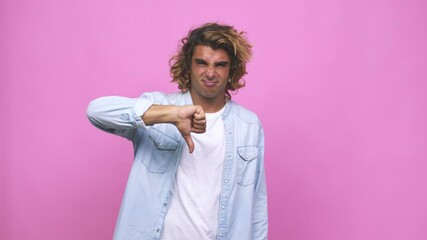 Wall Mural - Young cool australian man showing a dislike gesture, thumbs down, disagreement concept