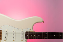 Close Up Olympic White Guitar On A Pink Gradient Background