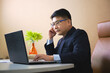© prasertpr - Image of asian business man using laptop while sitting in office