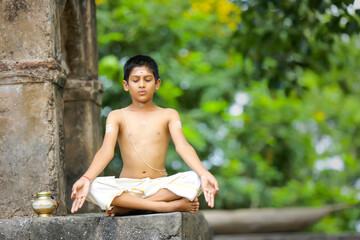  indian priest child doing yoga at park