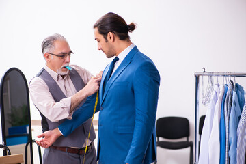 Young businessman visiting old male tailor