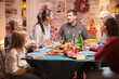 © DC Studio - Cheerful husband and wife looking at each other at christmas family dinner.