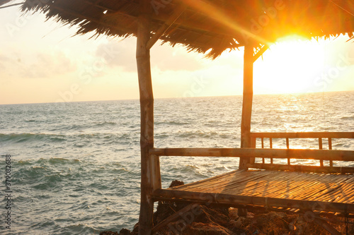 Fotomural View of a small hut near the ocean during sunset