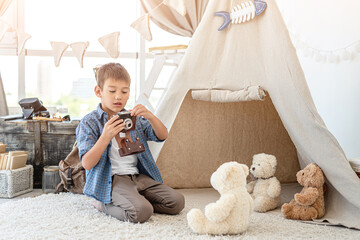 Wall Mural - Little boy taking picture of plush teddy