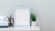 © NAMPIX - Mockup white wooden picture frame with clean towels, toothbrush  and houseplant on white wooden top table.