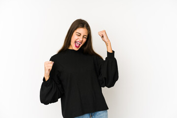 Wall Mural - Young caucasian woman isolated on white background raising fist after a victory, winner concept.