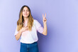 © Asier - Young caucasian woman isolated on purple background taking an oath, putting hand on chest.