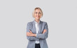 Portrait of happy confident businesswoman standing with crossed arms on light studio background, panorama