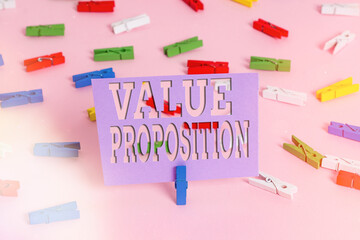 Handwriting text writing Value Proposition. Conceptual photo feature intended to make a company or product attractive Colored clothespin papers empty reminder pink floor background office pin