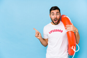 Wall Mural - Young handsome lifeguard man isoalted pointing to the side