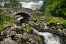 Stunning Long Exposure Landscape Image Of Ashness Bridge In English Lake District During Late Summer Afternoon With Dramatic Lighting