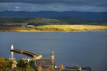 Wall Mural - Rocky shores, cliffs, mountain peaks,woodland and hills of Crinan Canal, panoramic aerial view. Ardrishaig, Argyll and Bute, Scotland, UK. Lighthouse close-up. Dramatic sky. Travel destinations