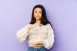 © Asier - Young chinese  woman isolated on a purple background holding something with both hands, product presentation.