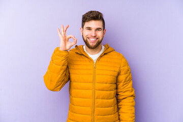 Canvas Print - Young man isolated on purple background cheerful and confident showing ok gesture.