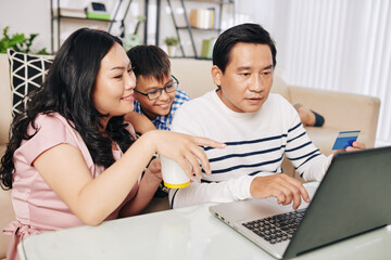 Poster - Vietnamese family gathered at laptop to make online purchases on Black Friday