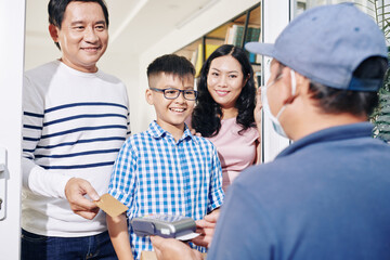 Poster - Cheerful Vietnamese family receiving package and paying for delivery