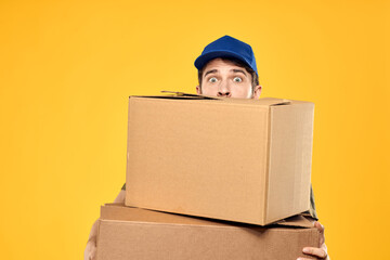 A man in a working form a box with loading tools yellow background