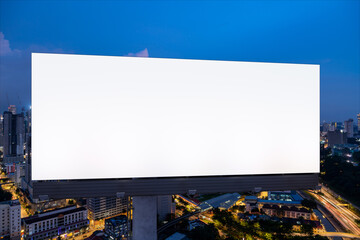 Blank white road billboard with KL cityscape background at night time. Street advertising poster, mock up, 3D rendering. Front view. The concept of marketing communication to promote or sell idea.