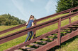 © Андрей Рыков - Ten year old caucasian girl walking up wooden stairs in green city park on sunny summer morning. The theme of moving to the future.