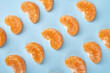 © DenisProduction.com - Rows of mandarin slices. Mandarin parts arranged in rows isolated on blue background.
