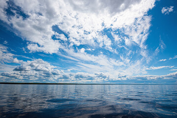 Wall Mural - panorama of calm lake, kama river blue sky with clouds reflected in the water.