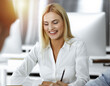 © Iryna - Group of business people discussing questions at meeting. Portrait of blond businesswoman in sunny office