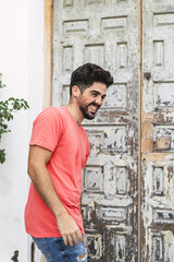 Poster - Vertical shot of a young smiling male in the street - happiness concept