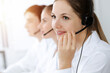 © rogerphoto - Call center. Beautiful young woman using headset and computer to help customers in sunny office. Business concept