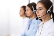 © rogerphoto - Call center. Group of operators at work. Focus at beautiful business woman in headset