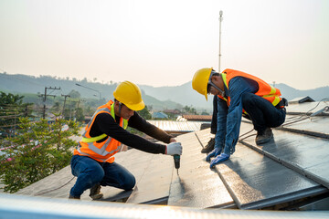 Wall Mural - Roofer builder worker installing ceramic roof on top of the new roof at construction site.