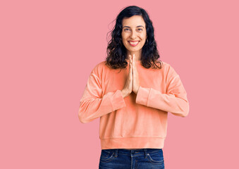 Young beautiful hispanic woman wearing casual clothes praying with hands together asking for forgiveness smiling confident.