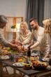 © pressmaster - Young and matue men holding tray with homemade roasted turkey over table