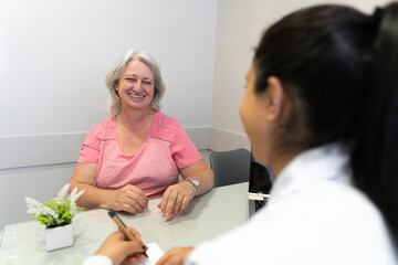 Joyful senior patient with big smile talking to doctor in doctors office health, medical, medicine concept..