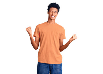 Young african american man wearing casual clothes very happy and excited doing winner gesture with arms raised, smiling and screaming for success. celebration concept.