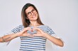 © Krakenimages.com - Beautiful caucasian woman wearing casual clothes and glasses smiling in love showing heart symbol and shape with hands. romantic concept.