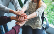 © Farknot Architect - Closeup image of business team standing and joining their hands together in office