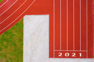 top down view of red running tracks with numbers and green grass lawn, infrastructure for sports activities