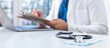 © kucherav - Online medicine concept. Stethoscope and medical mask on the doctors desk in the background, the doctor giving a remote medical consultation over internet