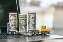 US USD 1, 5, 100 Dollar Bills, A Trailer Truck On A Laptop Computer, Depicts Wasting Time And Paying A Lot Of Money To Buy Things Online Called Online Shopping Or Retail E-commerce, Ecommerce Concept