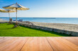 Image of rustic wood table in front of beautiful beach resort blurred background. Brown wooden empty counter in front of the sea and outdoor spa.
