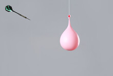 Throwing Of Dart In Balloon With Water On Grey Background