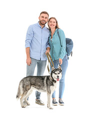 Sticker - Young couple with cute Husky dog on white background